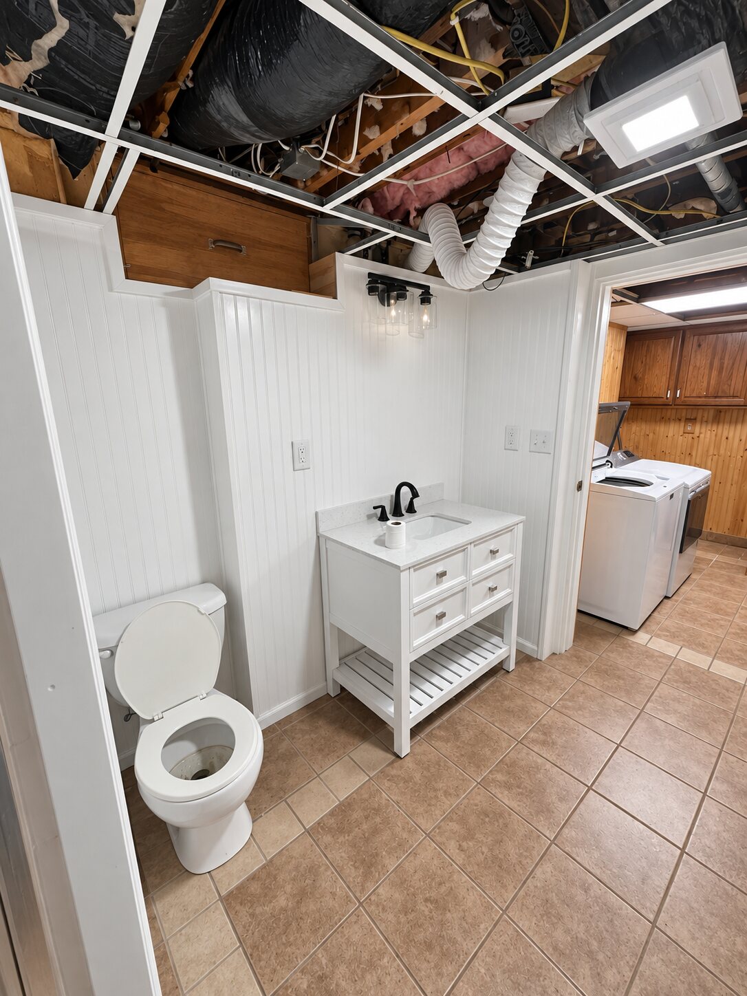 Wide view of the completed bathroom conversion beside the laundry area